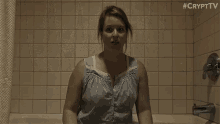 a toilet is sitting in a bathroom next to a bathtub with a shower curtain hanging from it .