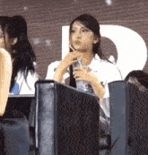 a woman sitting in a stadium with a bottle of water in her hand