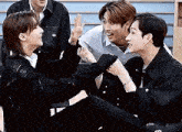 a group of young men are sitting next to each other on a bench .