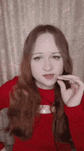 a woman with long red hair wearing a red top