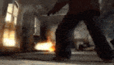 a man is standing in a room with a fire coming out of it .