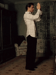 a shirtless man is standing in a room taking off his pants