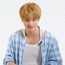 a young man wearing a blue tie dye shirt and a white tank top is standing in front of a white background .