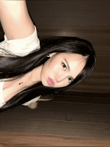 a woman with long black hair is taking a picture of herself