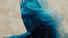 a close up of a woman 's face with blue hair .