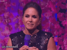 a woman in a sequined dress is holding a microphone and smiling