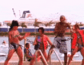 a group of people dancing on a dock with a boat in the background