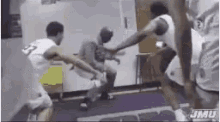 a group of basketball players are playing a game in a locker room .