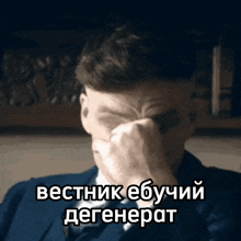 a man in a suit and tie is covering his face with his hand with a caption in russian