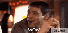 a man is sitting at a table in a restaurant with his mouth open and says wow .