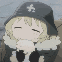 a girl in a black hat with a cross on it is holding a stuffed animal .