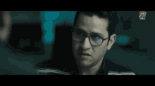 a close up of a man wearing glasses with a mbc logo