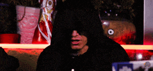 a man wearing a black hooded sweatshirt with a sticker that says ' nintendo ' on the bottom right