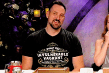 a man wearing an invulnerable vagrant t-shirt