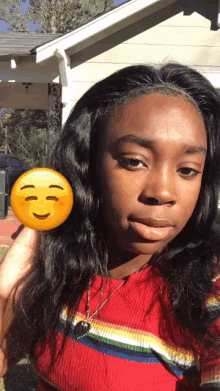 a woman is taking a selfie with a smiley face on her hair