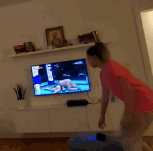 a woman in a pink shirt is standing in front of a tv that says ufc