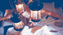 a person laying on a bed with lanterns hanging from the ceiling and the word torree on the bottom right