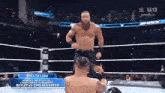 a man without a shirt is standing in a wrestling ring with another man .