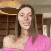 a woman in a pink top has a tattoo on her chest that says lola
