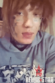 a person wearing a rehab star hoodie with a tattoo on their face