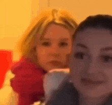 two women are posing for a picture together and one of them is wearing a red shirt .