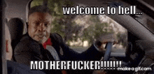 a man in a suit and tie is driving a car and saying welcome to hell motherfucker .