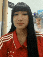 a girl with long black hair is wearing a red shirt