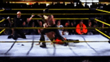 a blurry picture of a wrestling match in a ring with a crowd watching