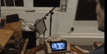 a man is playing a video game on a nintendo switch while sitting in front of a microphone .
