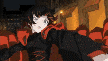 a girl in a black and red outfit stands in front of a crowd of red seats