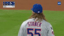 a baseball player with a ponytail wearing a blue hat with the letter m on it