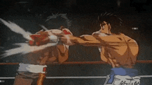 two men are boxing in a ring and one of them is throwing a punch .
