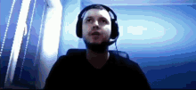 a man wearing headphones and a headset is looking up at the sky .