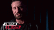 a man with a beard is standing in front of a digital exclusive banner