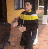 a man in a yellow and black jacket is dancing