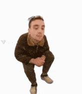 a man in a brown jacket is squatting down on a white background .