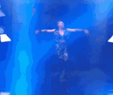 a blurry picture of a person dancing in front of blue lights
