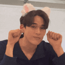 a young man wearing a cat ear headband making a funny face