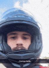 a man wearing a helmet with the words j'arrive tarlik on the bottom right