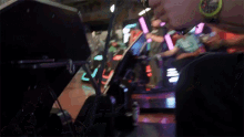 a person wearing a yellow watch is playing a video game in a dark room