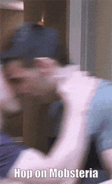 a blurry picture of a man with the words hop on mobsteria above him
