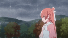 a girl with long red hair is standing in the rain with trees in the background