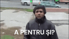 a man in a black jacket is standing in front of a sign that says " a pentru si "