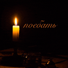 a lit candle in a candle holder with the word noeoam on the bottom left