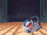 a cartoon shark is laying on the floor with a necklace that says ' shark ' on it