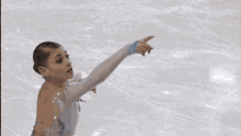 a woman in a white and blue dress is skating on a rink