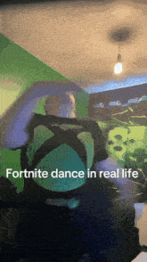 a man in a green shirt is dancing with the words " fortnite dance in real life " below him