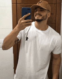 a man wearing a ny hat takes a picture of himself