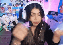 a woman wearing headphones and a microphone is sitting in front of a computer .