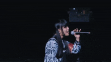 a group of girls singing into microphones on a stage with a blue background